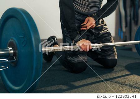 Strength training session with weights on the gym floor during a morning workout Strength training session with weights on the gym floor during a morning workout 122902341
