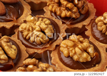 Delicious walnut pastries topped with rich chocolate filling and perfectly toasted nuts 122902427