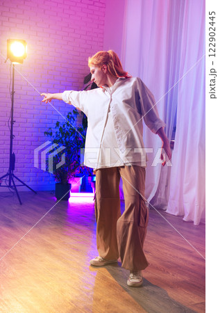 Young dancer expresses emotion through movement in a brightly lit studio during a contemporary dance rehearsal 122902445