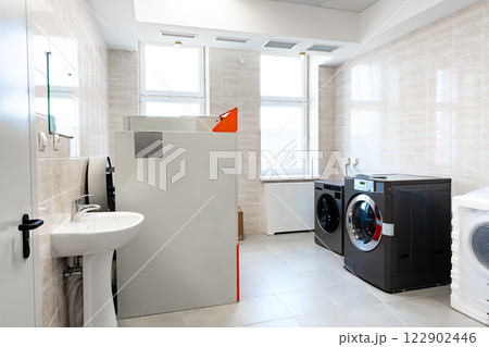 Laundry room featuring modern washer and dryer set in a bright, clean space with a white and gray color scheme Laundry room featuring modern washer and dryer set in a bright, clean space with a white and gray color scheme 122902446