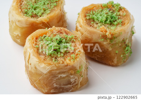 Delightful layers of baklava filled with nuts and topped with green pistachio garnish served at a dessert cafe 122902665