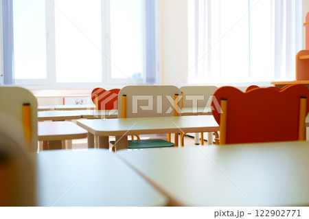 Bright classroom with empty desks and colorful chairs ready for students in a learning environment Bright classroom with empty desks and colorful chairs ready for students in a learning environment 122902771