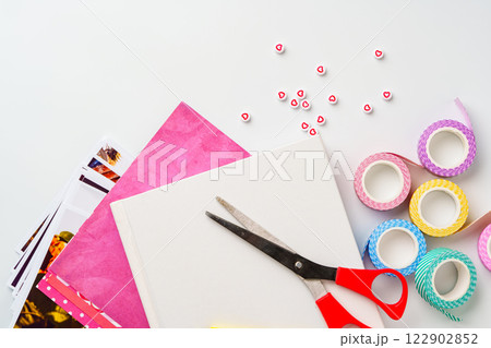 Crafting materials arranged on a flat surface with colorful tape, scissors, and decorative paper for creative projects Crafting materials arranged on a flat surface with colorful tape, scissors, and decorative paper for creative projects 122902852