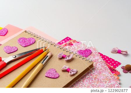 Crafting project with decorative supplies on a table featuring scissors, pencils, and colorful paper 122902877