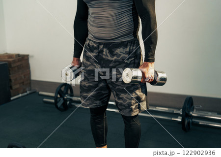 Weight training session in gym with dumbbells for muscle building and strength improvement 122902936