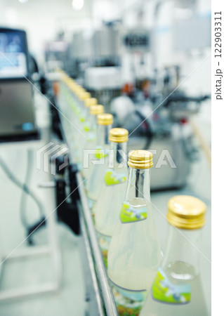 Production line of beverage bottling in a modern factory during daytime operations 122903311