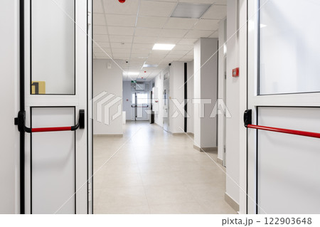 Modern hospital corridor showcasing clean lines and bright lighting in a well-maintained healthcare facility 122903648