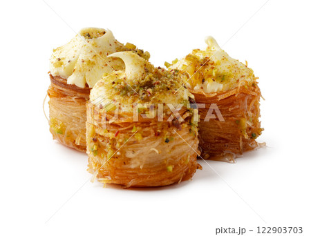 Delicious stacked pastry with cream and nut topping served on a white background for an enticing dessert experience 122903703