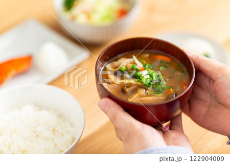 和食の朝食を食べるミドル女性の手元 122904009