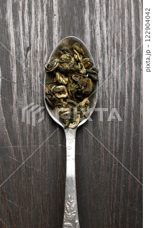 Tea in a spoon on a wood Tea in a spoon on a wood 122904042