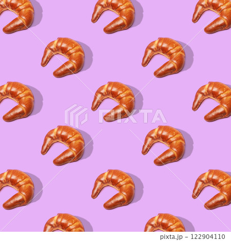 Baking croissant roll on purple background. Top view. Pop art design. Baking croissant roll on purple background. Top view. Pop art design. 122904110