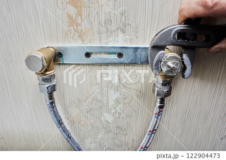 An adjustable pliers wrench is used to fasten pipe plugs, securing them tightly to plumbing mount. 122904473