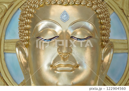close up of golden Buddha statue is a stunning sight to behold. The intricate details and craftsmanship of the sculpture are clearly visible, showcasing the skill and talent of artist who created it. close up of golden Buddha statue is a stunning sight to behold. The intricate details and craftsmanship of the sculpture are clearly visible, showcasing the skill and talent of artist who created it. 122904560