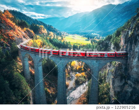Aerial view of red train on Landwasser viaduct in autumn in Alps 122905216