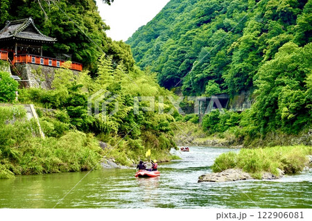 保津川下りのラフティングのゴムボートが請田神社の下を通る風景　京都府亀岡市 122906081
