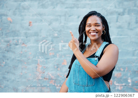 Black woman, portrait and pointing to mockup background wall space for advertising, marketing news and announcement in urban city outdoors. Happy, smile and young hipster gen z girl promote message 122906367