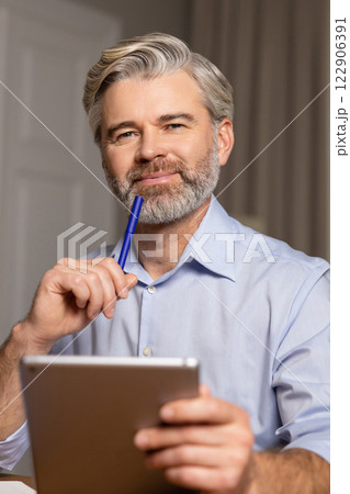 Waist up of a mid aged bearded man with a notebook and a pen in hand Waist up of a mid aged bearded man with a notebook and a pen in hand 122906391