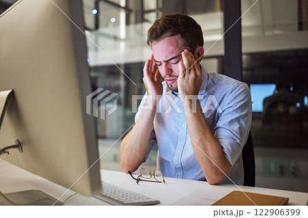 Stress, depression and mental health for night business man sitting at his computer desk with headache, anxiety and burnout from work pressure. Stressed male working late in his Australia office 122906399