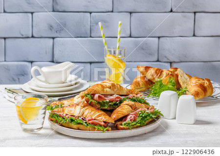 croissant sandwiches with ham and lettuce on plate 122906436