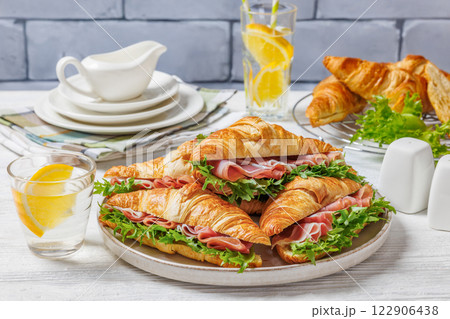 croissant sandwiches with ham and lettuce on plate croissant sandwiches with ham and lettuce on plate 122906438