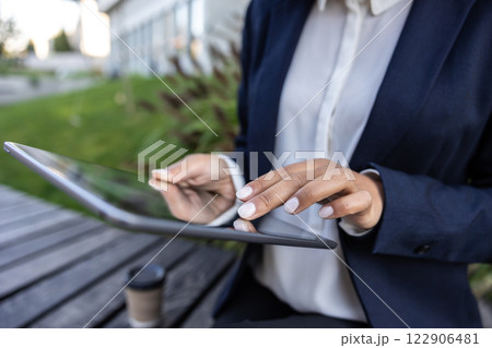 Close up of womans hands scrolling something on a tablet 122906481