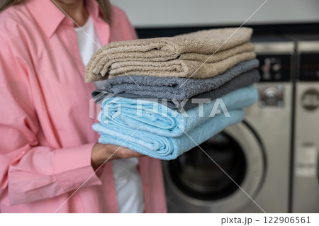Contented mature caucasian woman holding a pile of clean clothes 122906561
