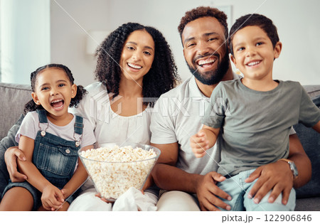 Love, laugh and watching tv or a movie with a happy family eating popcorn, having fun and smile together in home. Portrait of latino parents and children, enjoy the weekend and feeling carefree 122906846