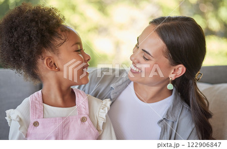 Love, mother and smile with her girl as they relax and laugh on the couch at home. Sweet moment between latin woman and child while bonding, happiness and hug with care together at home as a family 122906847