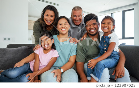 Family, children and love with kids, grandparents and parents sitting on a sofa in the living room of their home during a visit. Happy, smile and together with a senior man, woman and their relatives 122907025