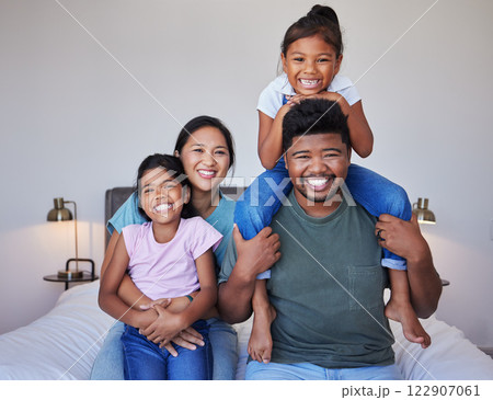 Happy family, portrait on bed in home bedroom and face smile bonding together. Love, happiness and caring Indian parents or father, mother and girls spending free time in comfort, support and care. Happy family, portrait on bed in home bedroom and face smile bonding together. Love, happiness and caring Indian parents or father, mother and girls spending free time in comfort, support and care. 122907061