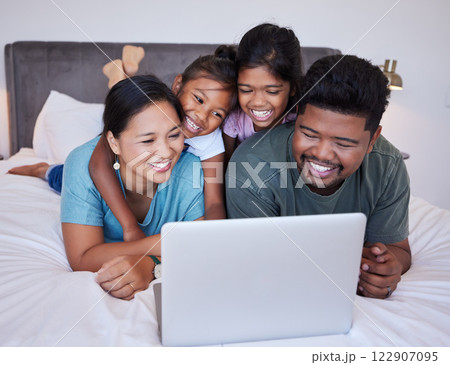 Happy family, relax and laptop on a bed together, bonding and streaming online in a bedroom. Love, mother, father and children rest in their home together, enjoying subscription and entertainment Happy family, relax and laptop on a bed together, bonding and streaming online in a bedroom. Love, mother, father and children rest in their home together, enjoying subscription and entertainment 122907095