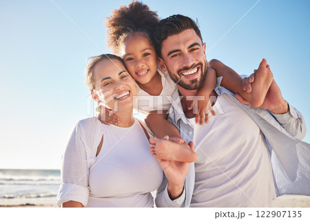 Family, children and beach with a girl and parents by the sea or ocean for a holiday with a view in portrait. Kids, love and nature with a mother, father and daughter by the water during summer 122907135