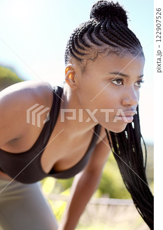 Motivation, focus and fitness black woman about to run a sport workout outdoor. Sports training, health exercise and athlete with a serious face expression about to start a strong cardio session Motivation, focus and fitness black woman about to run a sport workout outdoor. Sports training, health exercise and athlete with a serious face expression about to start a strong cardio session 122907526