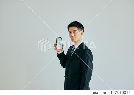 スマホを持つ20代の若い男性　新NISA&iDeCo 122910016