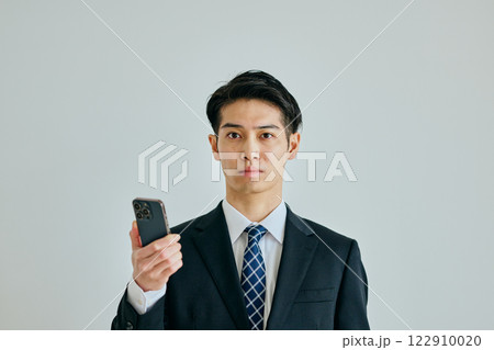 スマホを持つ20代の若い男性 122910020