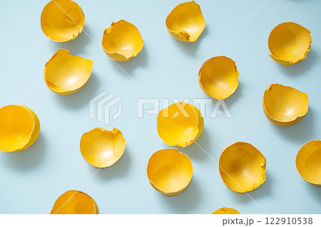 Cracked Yellow Easter Eggshells on Blue Background. Spring Symbolism, Fragile Beauty. Cracked Yellow Easter Eggshells on Blue Background. Spring Symbolism, Fragile Beauty. 122910538