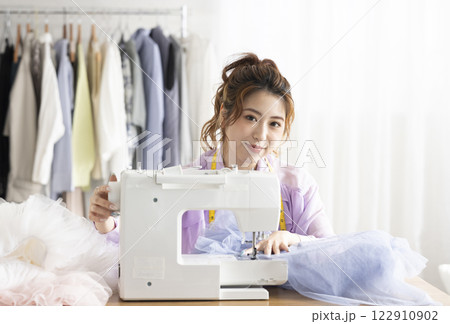ミシンを使うかわいい女性 122910902