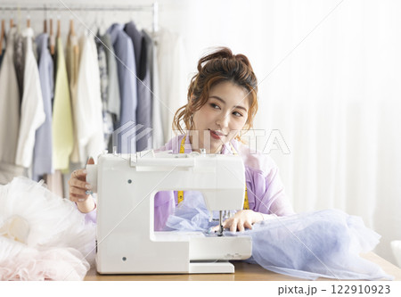 ミシンを使うかわいい女性 122910923