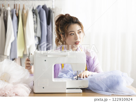 ミシンを使うかわいい女性 122910924
