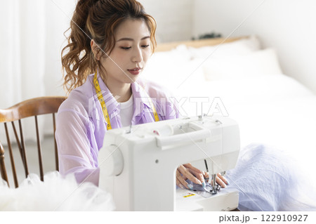 ミシンを使うかわいい女性 122910927