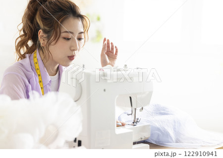 ミシンを使うかわいい女性 122910941