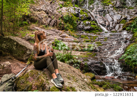 Woman Solo Traveler Sitting near Mountain Waterfall 122911631