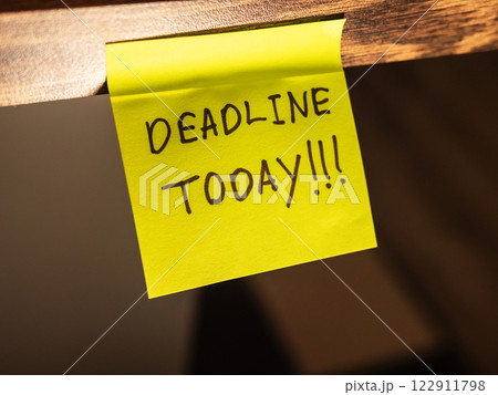 Bright sticky note with a reminder about the deadline today, placed on a desk 122911798