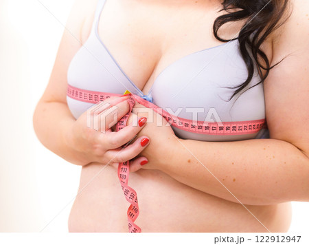 Woman measuring her chest breasts bust size Woman measuring her chest breasts bust size 122912947