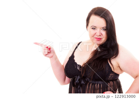 Woman plus size in lingerie pointing at copy space Woman plus size in lingerie pointing at copy space 122913000