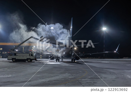 Ground deicing of a passenger jetliner on the night airport at winter 122913692