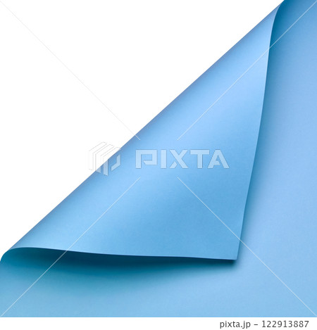 A clean and minimalist composition featuring a sheet of smooth blue paper curled at the corner. The vibrant color and elegant fold create a dynamic yet simple visual element A clean and minimalist composition featuring a sheet of smooth blue paper curled at the corner. The vibrant color and elegant fold create a dynamic yet simple visual element 122913887