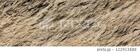 A close up of a rough, cracked rock surface with earthy brown and beige tones. The natural texture and weathered details make it ideal for backgrounds, geology themes, and organic material references. A close up of a rough, cracked rock surface with earthy brown and beige tones. The natural texture and weathered details make it ideal for backgrounds, geology themes, and organic material references. 122913888