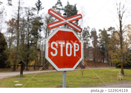 The sign of a stop at a railway crossing. A red mark on a railway station The sign of a stop at a railway crossing. A red mark on a railway station 122914119