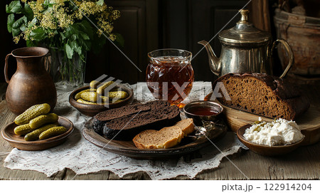 A table with a variety of food items including bread, pickles, and tea. Scene is cozy and inviting, with the food items arranged in a way that makes them look delicious and ready to be eaten A table with a variety of food items including bread, pickles, and tea. Scene is cozy and inviting, with the food items arranged in a way that makes them look delicious and ready to be eaten 122914204